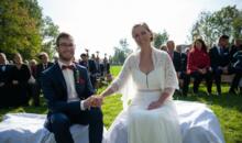 Das Brautpaar heiratet im Freien auf einer Wiese