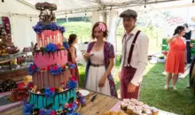 Das Brautpaar an der Hochzeitstorte bei der Festival-Hochzeit.