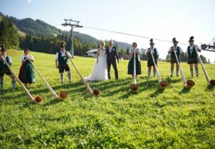 Brautpaar mit Alphornbläsern vor Allgäuer Bergkulisse: freie Trauung auf der Meckatzer Sportalp, Oberjoch bei Hindelang im Allgäu